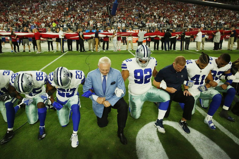 Dallas Cowboys players and staff members, including owner Jerry Jones and head coach Jason Garrett, all take a knee before the singing of the National Anthem before the start of a game against the Arizona Cardinals at University of Phoenix Stadium on Monday (Andy Jacobsohn/Dallas Morning News)